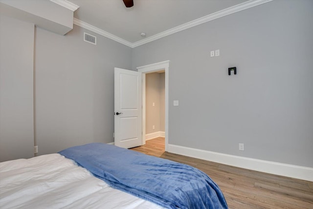 bedroom with hardwood / wood-style floors, ceiling fan, and crown molding