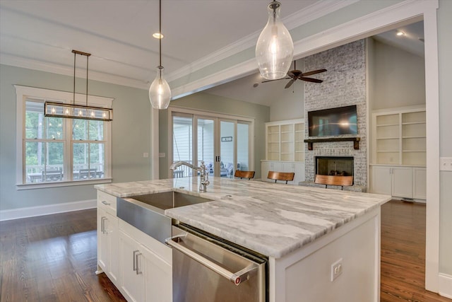 kitchen featuring dishwasher, white cabinets, ceiling fan, an island with sink, and decorative light fixtures