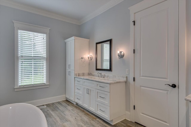 bathroom featuring hardwood / wood-style flooring, vanity, crown molding, and a bath