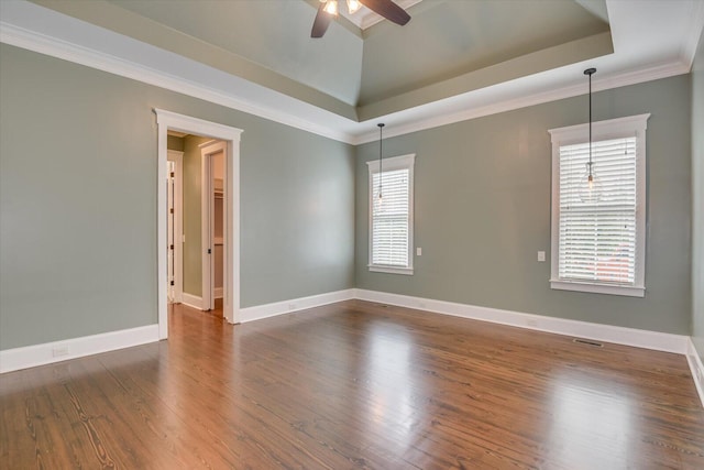 unfurnished room with a tray ceiling, ceiling fan, ornamental molding, and dark hardwood / wood-style floors