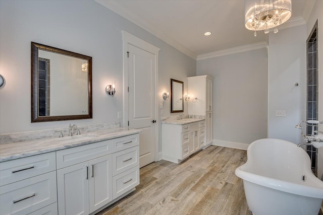 bathroom featuring a tub, a notable chandelier, crown molding, vanity, and hardwood / wood-style flooring