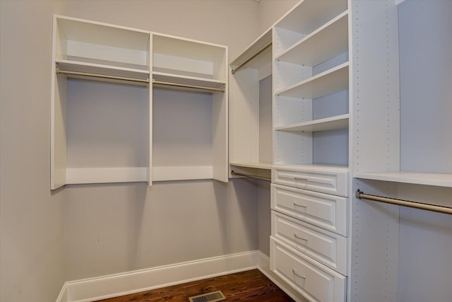 spacious closet with dark hardwood / wood-style floors