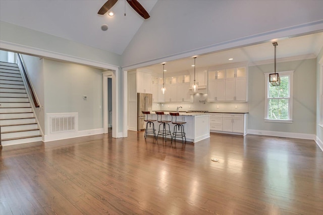 unfurnished living room featuring ceiling fan, dark hardwood / wood-style flooring, and high vaulted ceiling