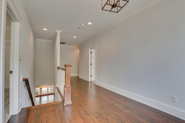 empty room with dark hardwood / wood-style flooring and crown molding