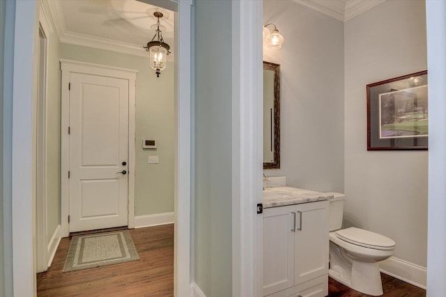 bathroom featuring crown molding, toilet, vanity, and hardwood / wood-style flooring