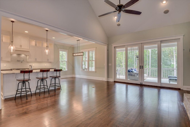 living room with ceiling fan, dark hardwood / wood-style floors, high vaulted ceiling, and french doors