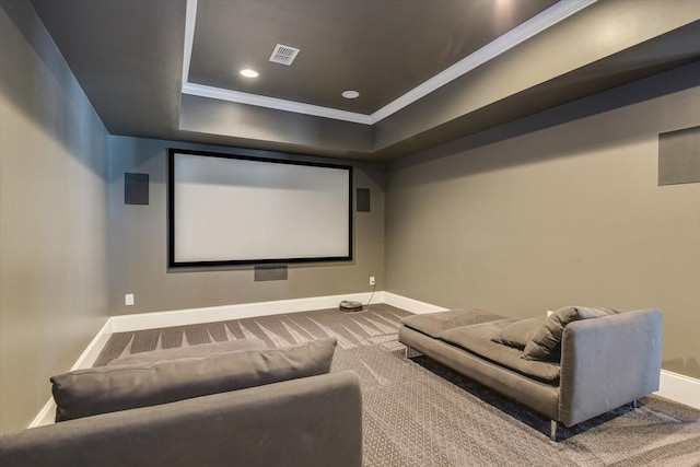 carpeted cinema with a tray ceiling and crown molding