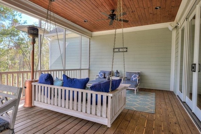 wooden deck with outdoor lounge area and ceiling fan