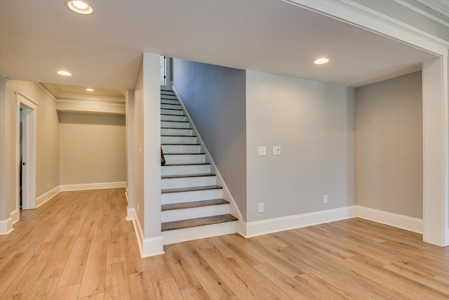 stairs with hardwood / wood-style floors and ornamental molding