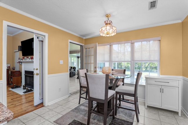 2795 Davis Mill Rd, Hephzibah, GA 30815 - dining area featuring light tile patterned floors, a fireplace with flush hearth, a wainscoted wall, ornamental molding, and visible vents