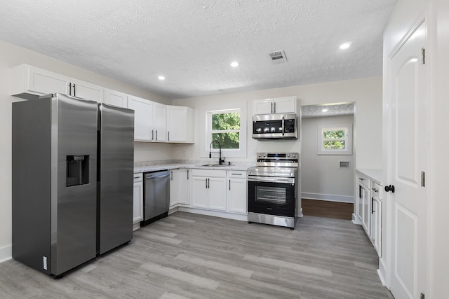 5 Elm St, Beech Island, SC 29841 - kitchen featuring stainless steel appliances, light countertops, white cabinets, a textured ceiling, and light wood-style flooring