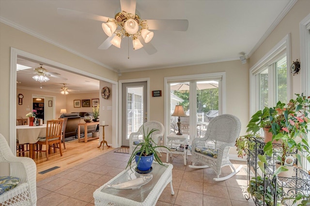 living room featuring ceiling fan, light tile patterned floors, and ornamental molding