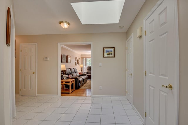 corridor featuring light tile patterned floors and a skylight