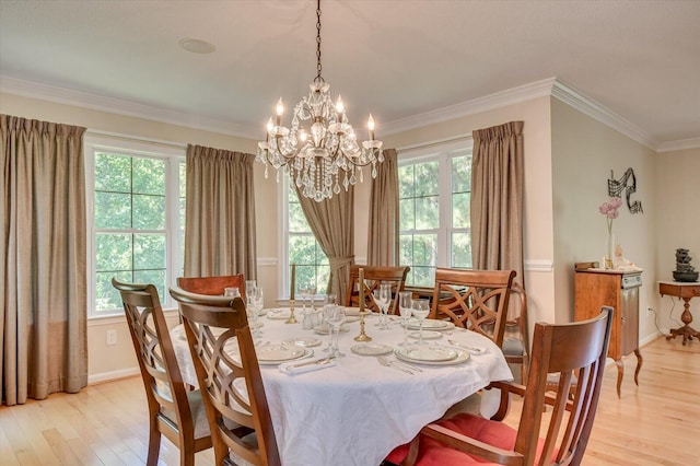 dining room with a chandelier, light wood-type flooring, and ornamental molding