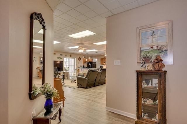 corridor with hardwood / wood-style flooring and a drop ceiling