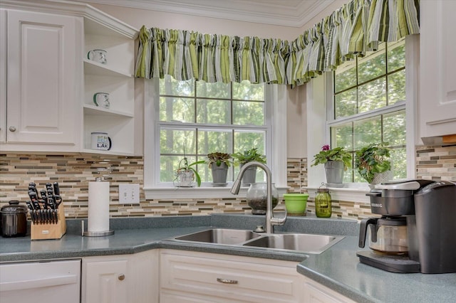 kitchen featuring white dishwasher, white cabinetry, plenty of natural light, and sink