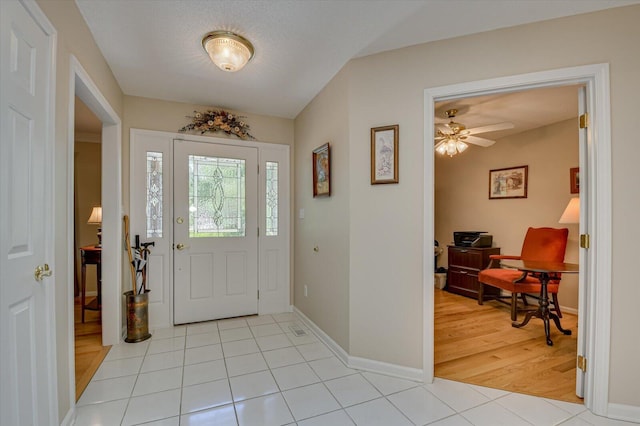 tiled foyer entrance featuring ceiling fan and a textured ceiling