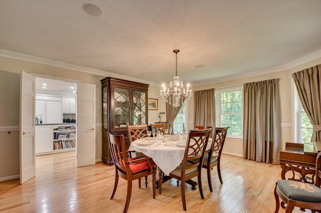 dining area featuring light hardwood / wood-style flooring, a chandelier, and ornamental molding