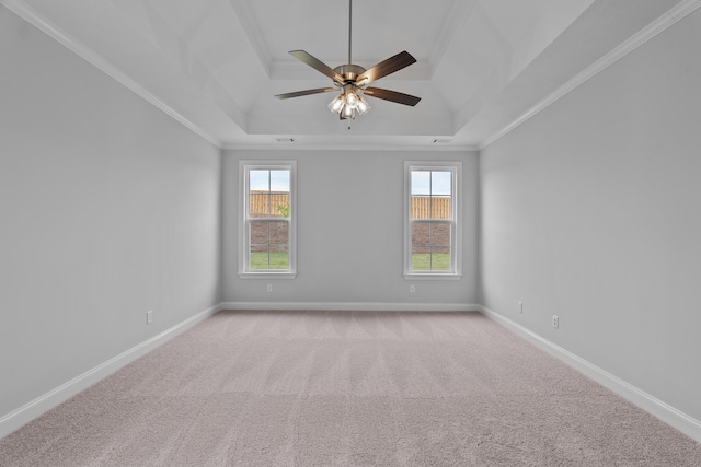 unfurnished room with a tray ceiling, ceiling fan, crown molding, and light colored carpet