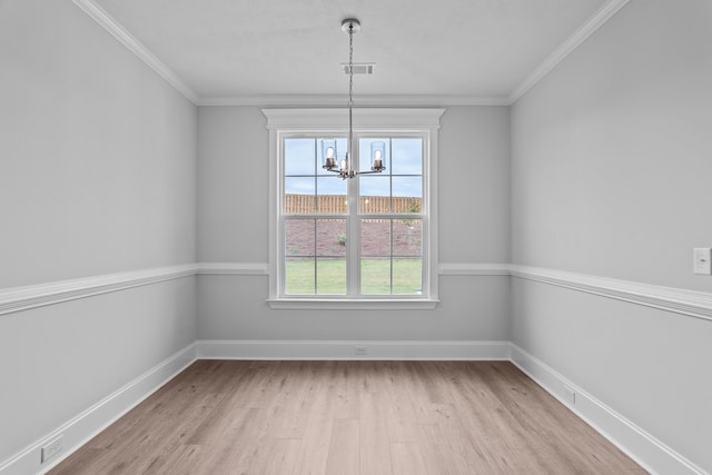 unfurnished dining area with ornamental molding, light hardwood / wood-style flooring, and a chandelier