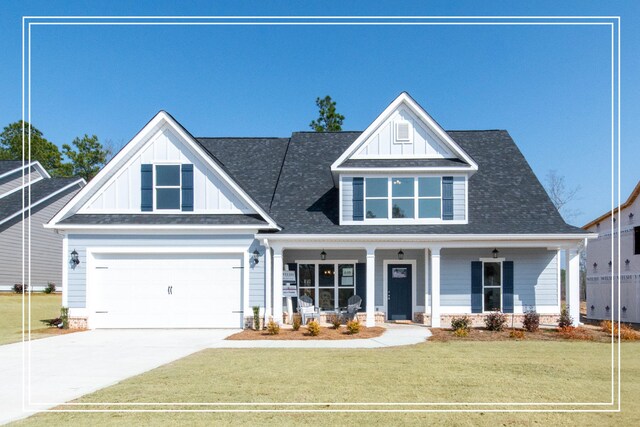 view of front of property with a front lawn, covered porch, and a garage