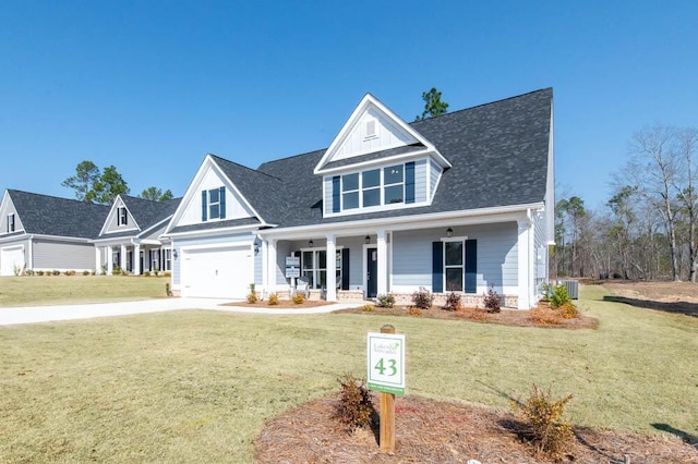 view of front of home with a garage, a front yard, and covered porch