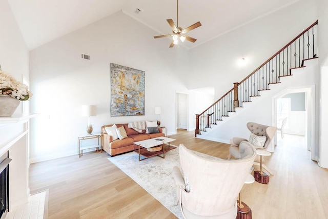 living room featuring high vaulted ceiling, ceiling fan, and light wood-type flooring