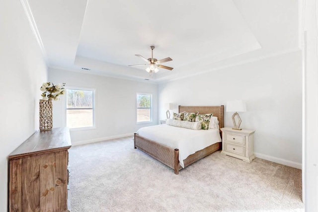 bedroom with ceiling fan, a tray ceiling, and light carpet