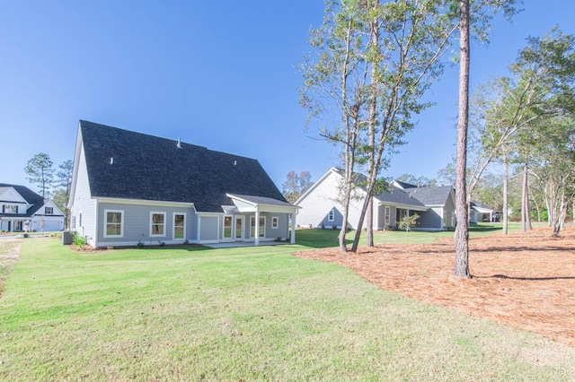 back of property featuring central AC unit and a lawn