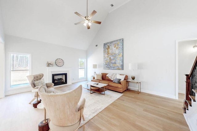 living room featuring high vaulted ceiling, ceiling fan, and light wood-type flooring