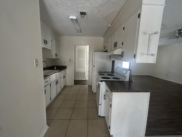 kitchen with white electric range oven, white cabinets, tile patterned floors, and sink