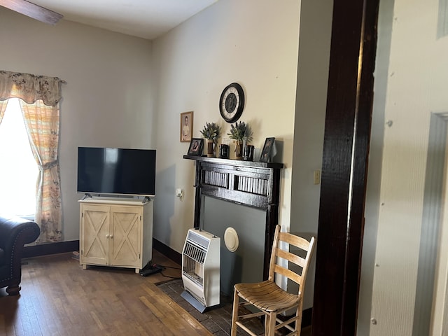 interior space with heating unit, a wealth of natural light, and dark hardwood / wood-style flooring