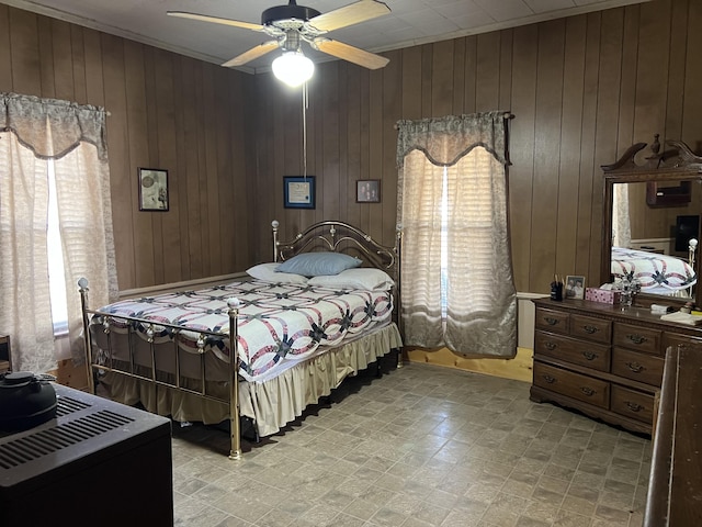 bedroom with ceiling fan and wooden walls