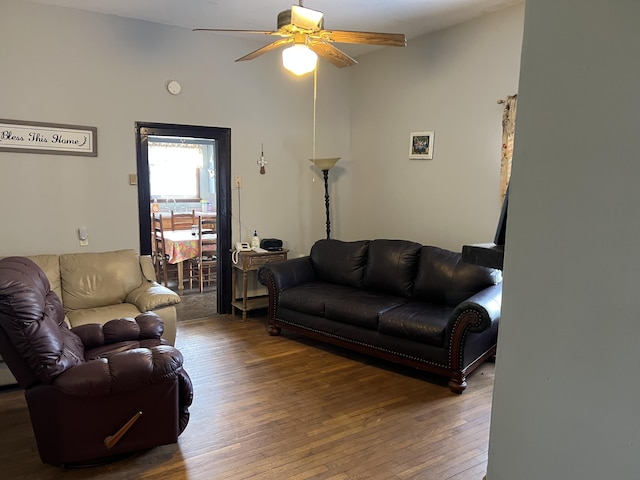 living room with ceiling fan and dark wood-type flooring