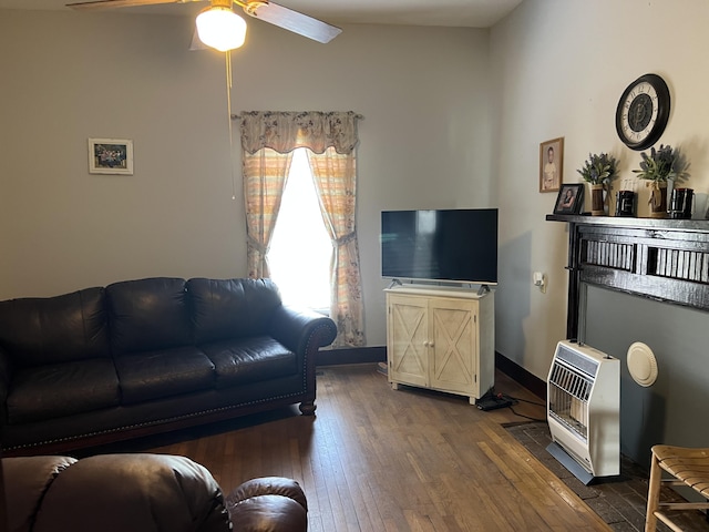 living room with heating unit, dark hardwood / wood-style flooring, and ceiling fan