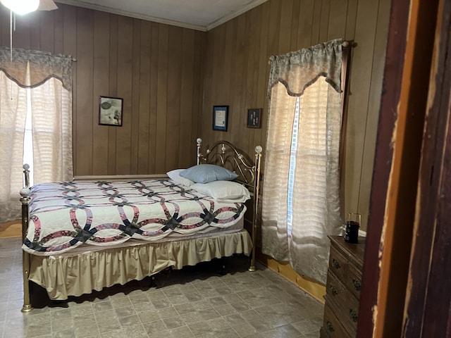 bedroom with ornamental molding and wood walls