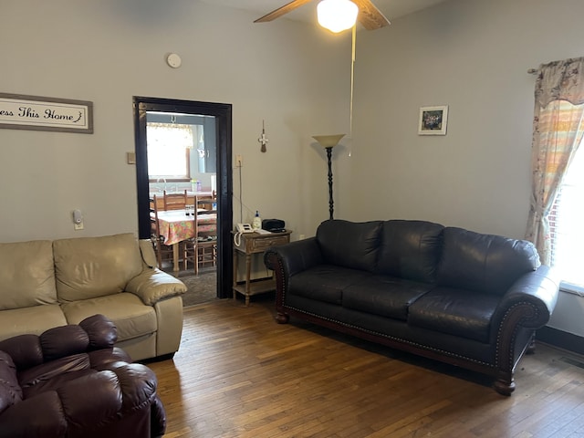 living room with ceiling fan and dark wood-type flooring