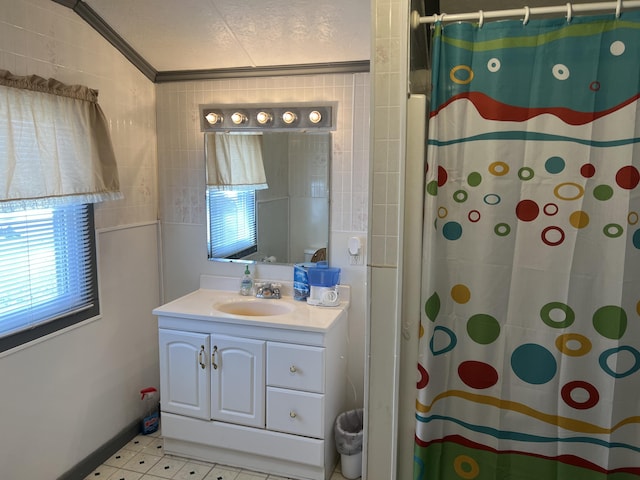 bathroom with lofted ceiling, a textured ceiling, vanity, walk in shower, and crown molding