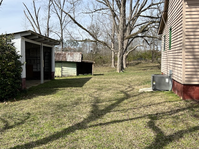 view of yard featuring an outbuilding and central AC unit