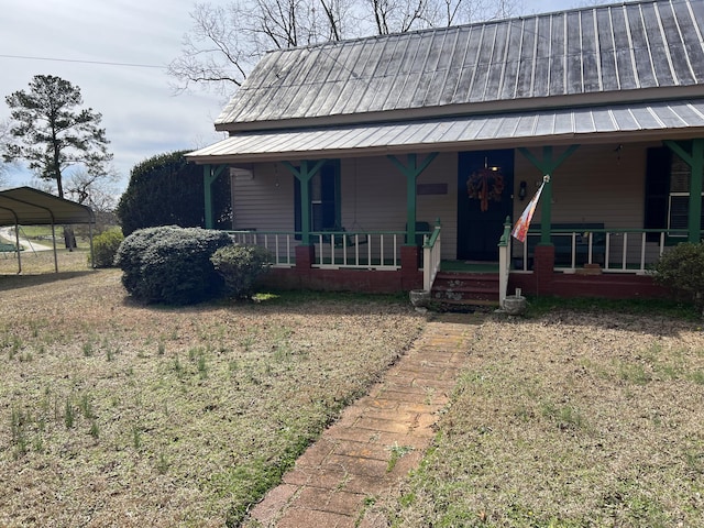 view of front facade featuring covered porch, a front yard, and a carport