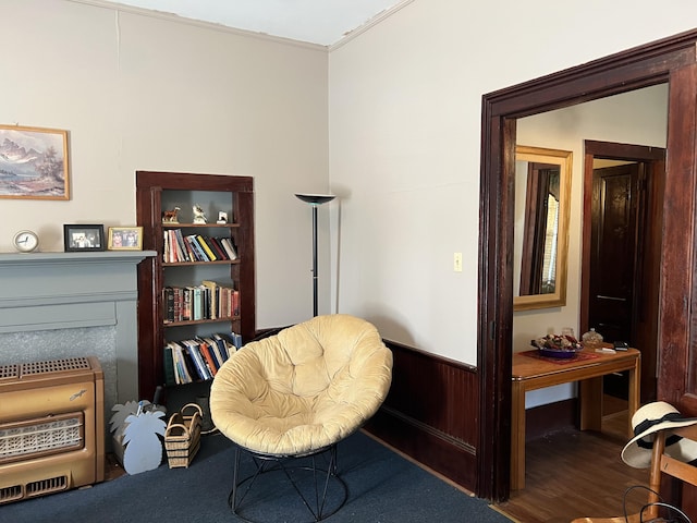 living area featuring heating unit, ornamental molding, hardwood / wood-style floors, and built in shelves