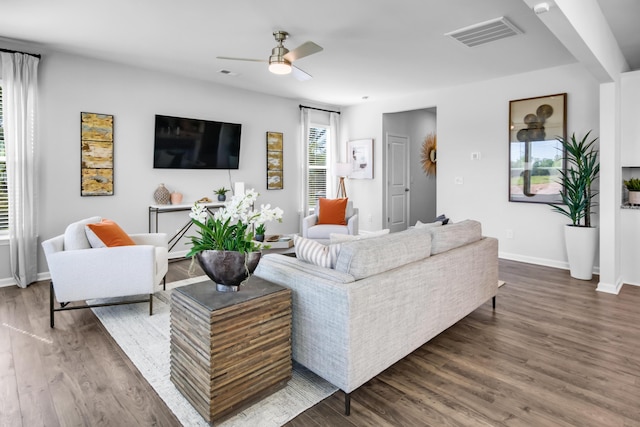 living room featuring ceiling fan and dark wood-type flooring