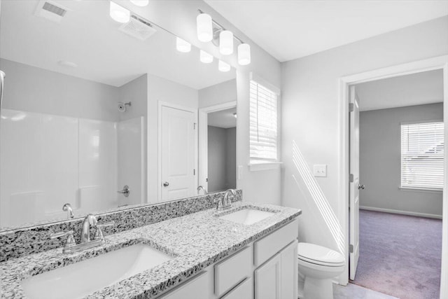 bathroom with toilet, a healthy amount of sunlight, and vanity