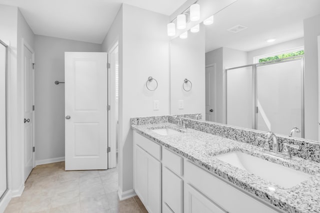 bathroom featuring a shower with shower door and vanity