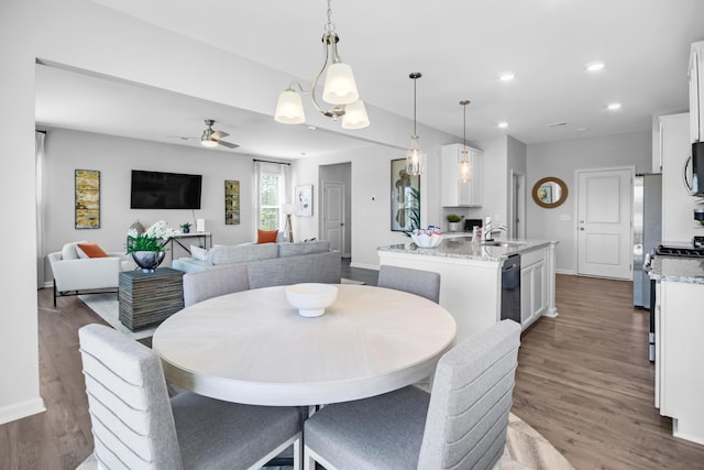 dining room featuring dark wood-type flooring, ceiling fan, and sink