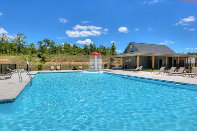 view of swimming pool with pool water feature and a patio