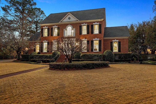 colonial inspired home with a lawn