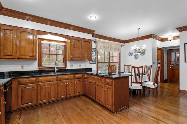 kitchen with dishwasher, sink, a healthy amount of sunlight, and decorative light fixtures