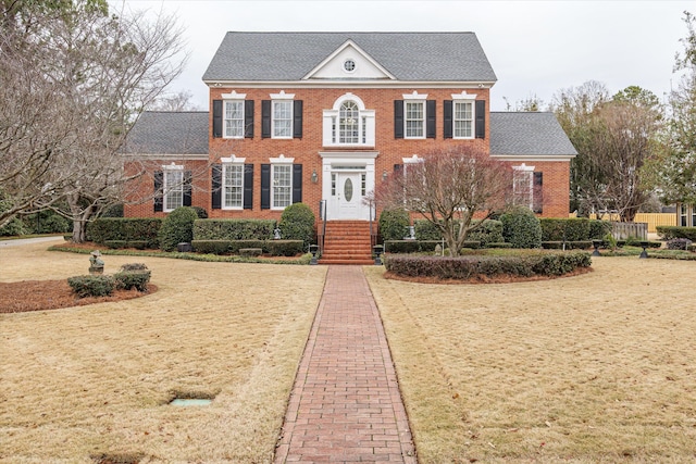 colonial inspired home with a front lawn