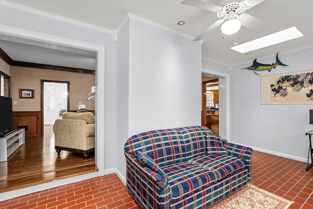 living room with crown molding, ceiling fan, and a skylight